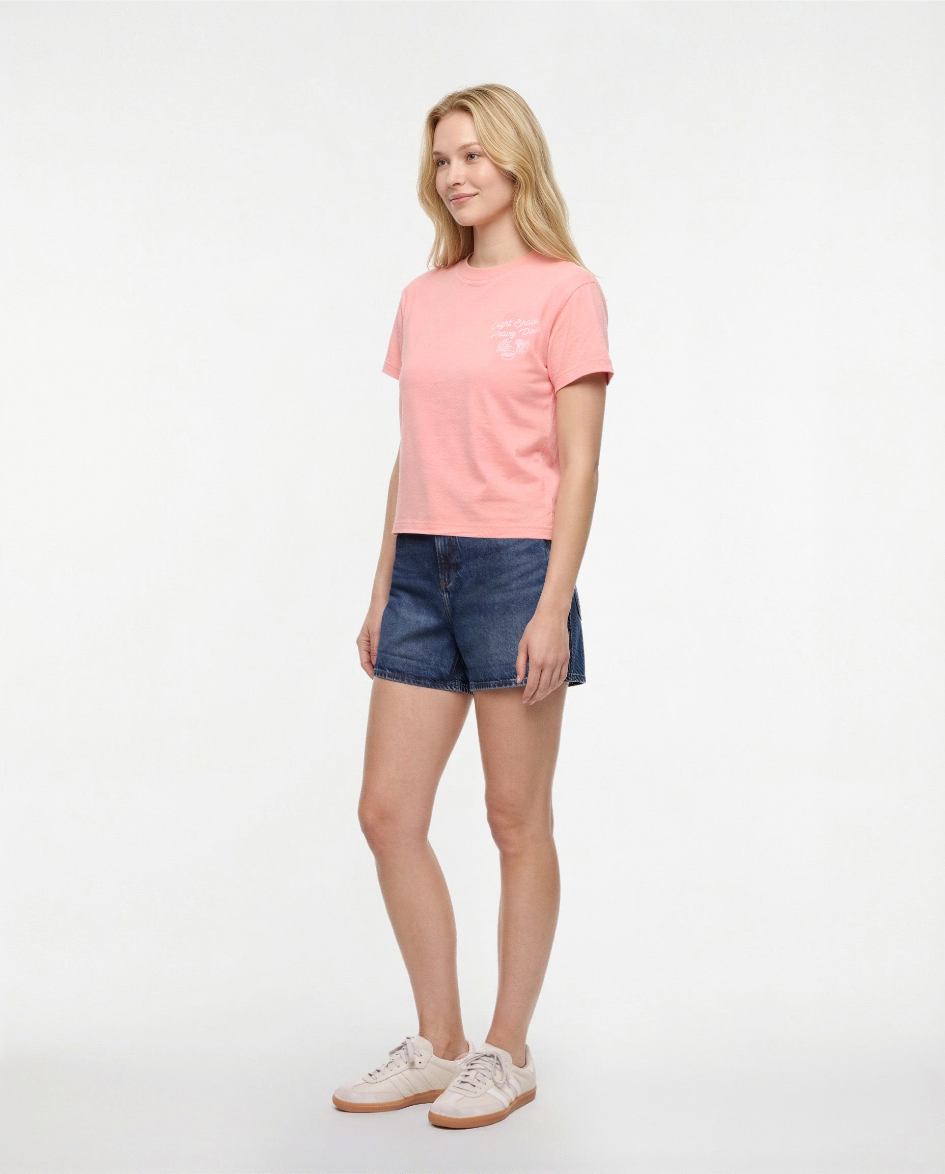 Side view of woman wearing a pale pink/red t-shirt with white &