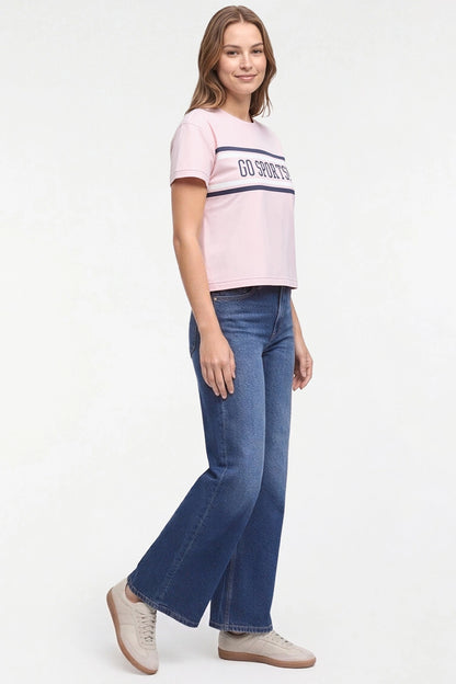 A woman modeling a light pink short-sleeve crop top with a navy blue stripe and &