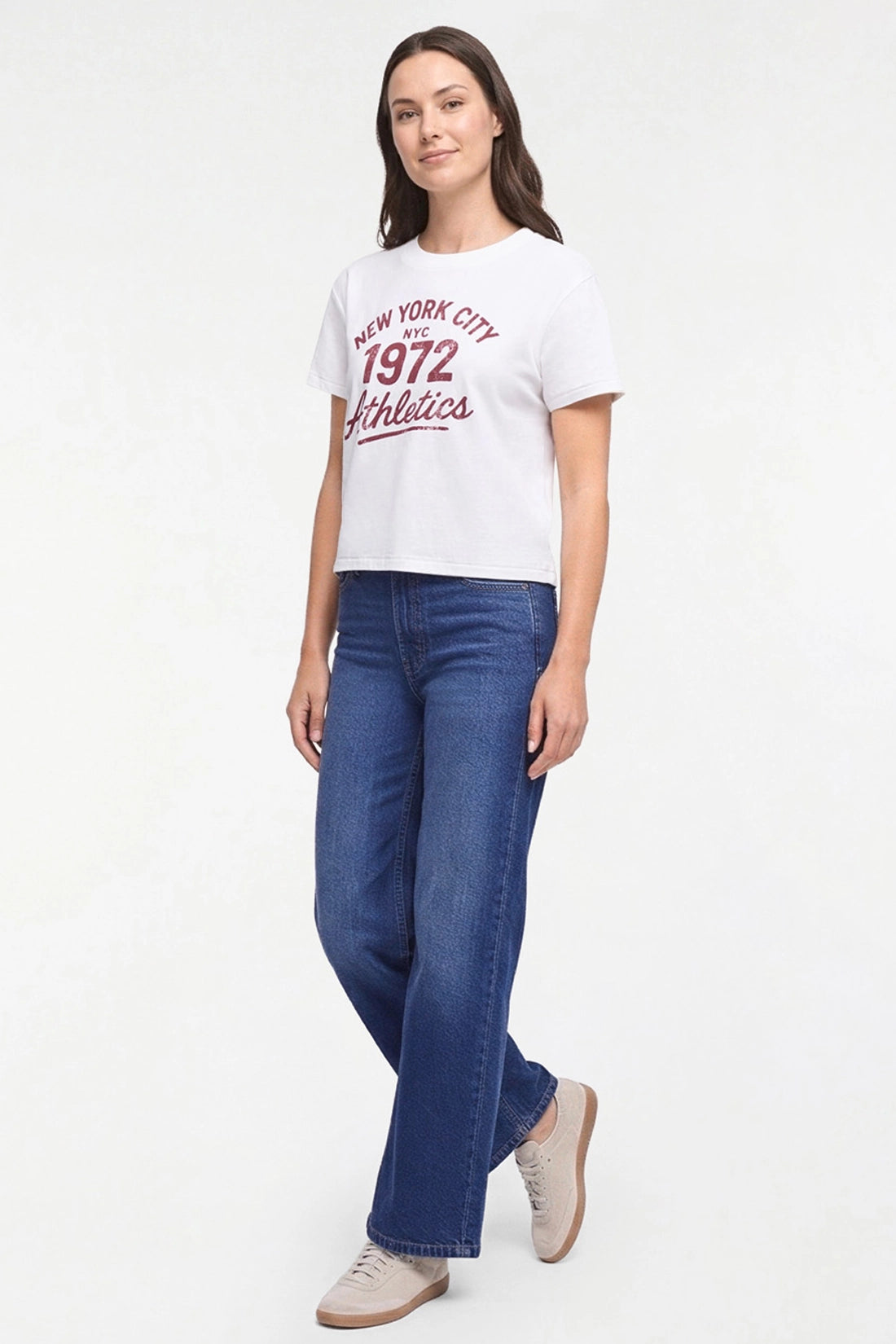 A woman modeling a white short-sleeve graphic T-shirt with red text reading &