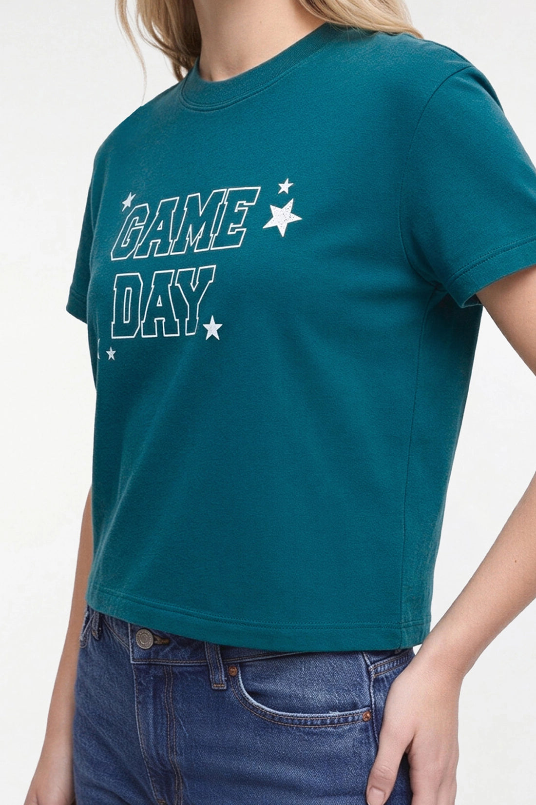 A woman wearing a teal cropped t-shirt with &