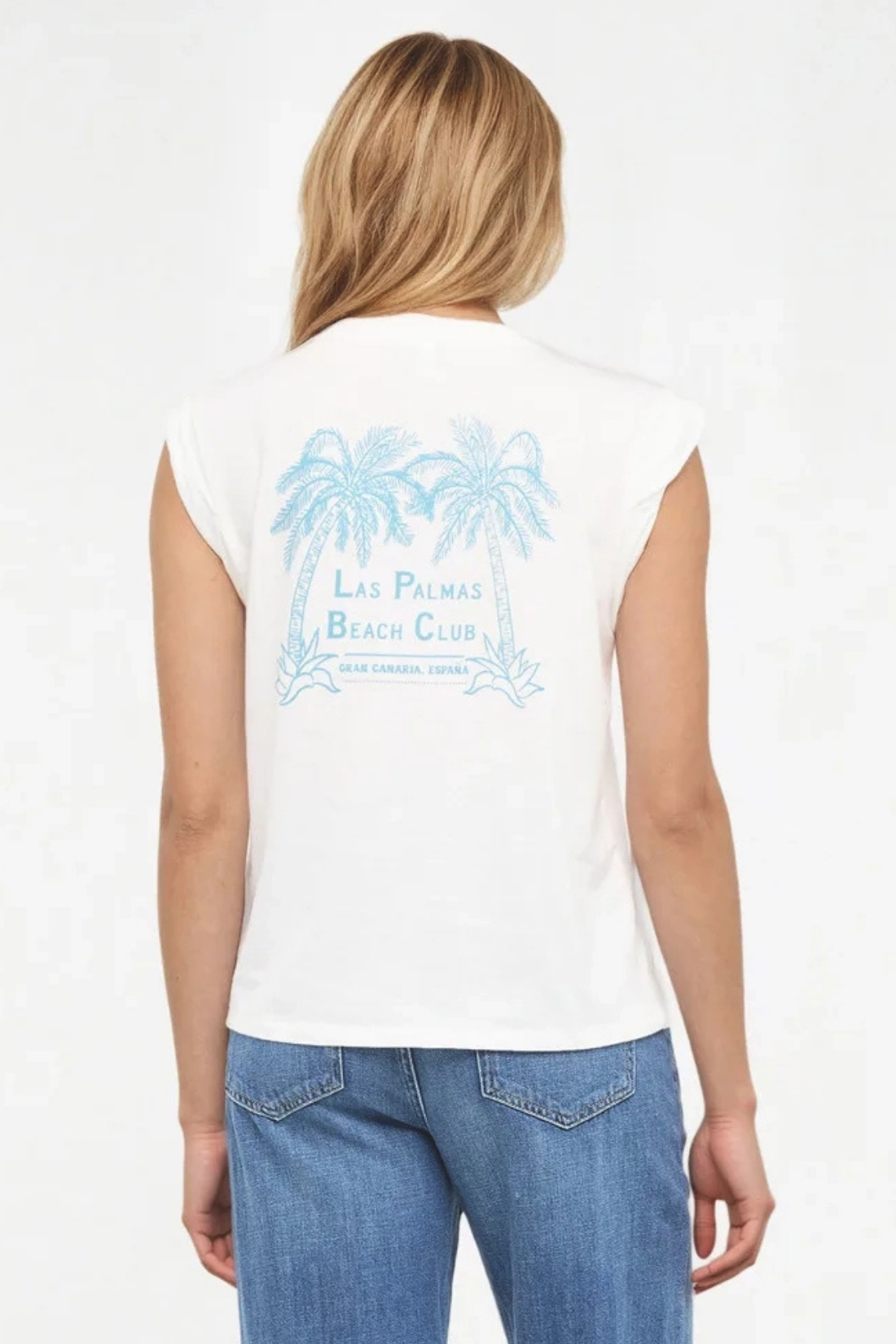 Back view of woman wearing a white t-shirt with "LAS PALMAS BEACH CLUB; GRAN CANARIA, ESPANA" text and graphic design featuring two palm trees and blue jeans on a white background. 