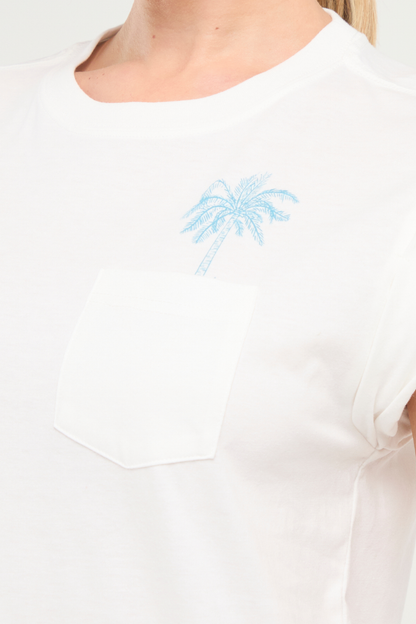 Close up white tee with a blue palm tree design on front pocket on a white background. 