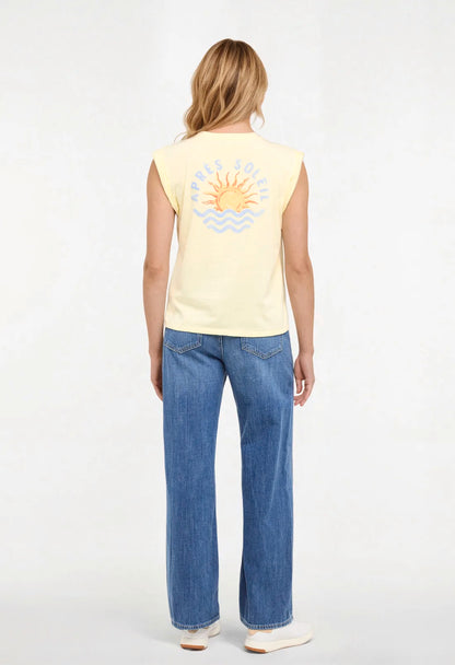 Back view of woman wearing a yellow sleeveless shirt with a sun and wave design and &