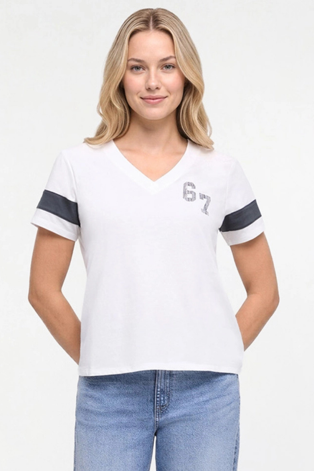 A woman wearing a white v-neck t-shirt with dark gray sleeve stripes and a gray &