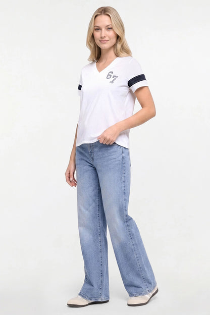 A woman modeling a white short-sleeve V-neck t-shirt with black sleeve stripes and a gray &
