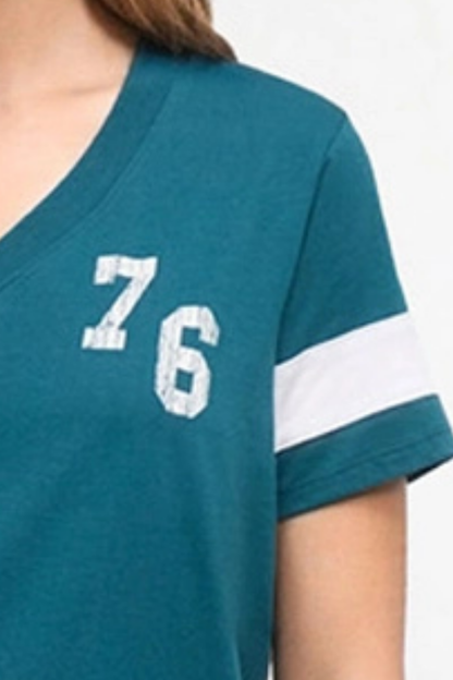 Close-up of a teal short-sleeve V-neck T-shirt with a white sleeve stripe and large white &