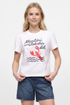 Front view of woman wearing a white t-shirt with &