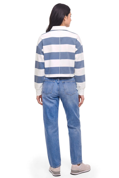 A model shown from the back wearing a blue and white horizontally striped cropped long-sleeve shirt and light blue jeans, against a plain white background. 