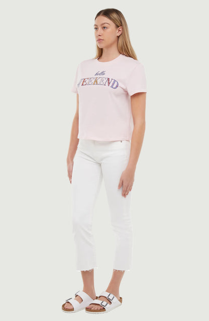 Quarter view of woman wearing a light pink t-shirt with colorful &