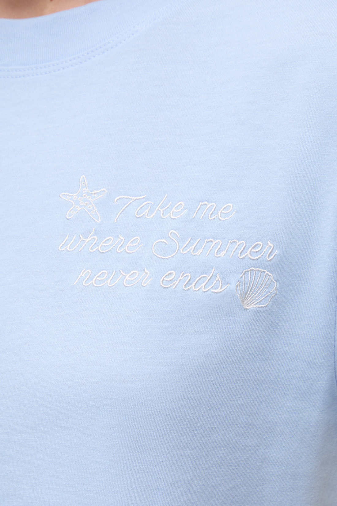 Close up front view of light blue shirt with embroidered &
