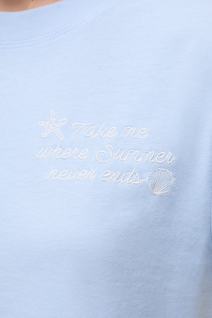 Close up front view of light blue shirt with embroidered &