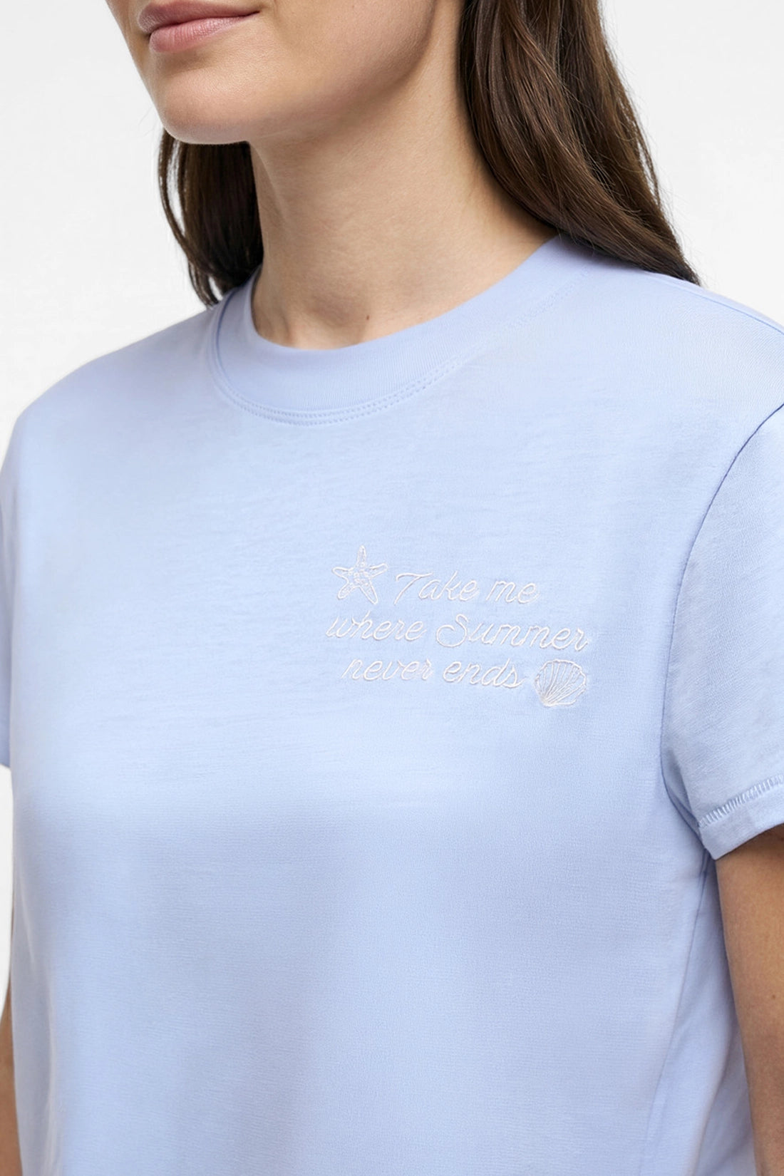 Close up front view of light blue shirt with embroidered &