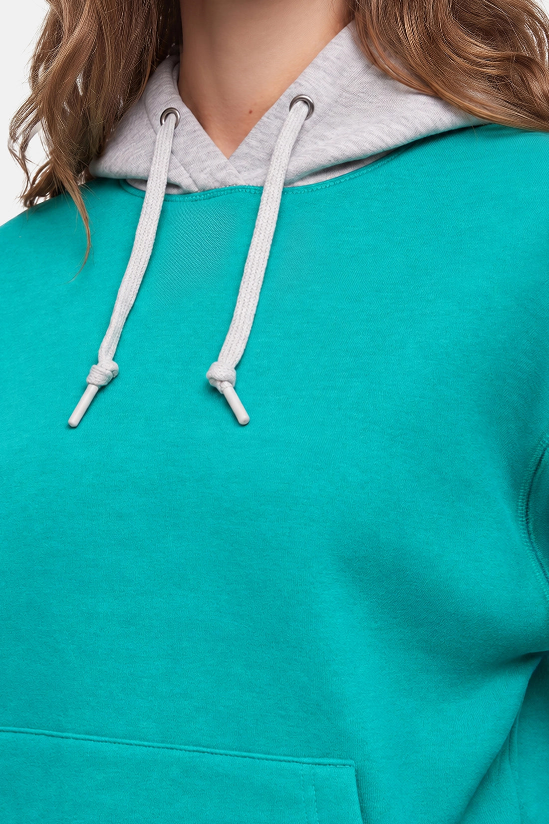Close-up of a person wearing a turquoise hoodie with a light gray inner hood and white drawstrings. 