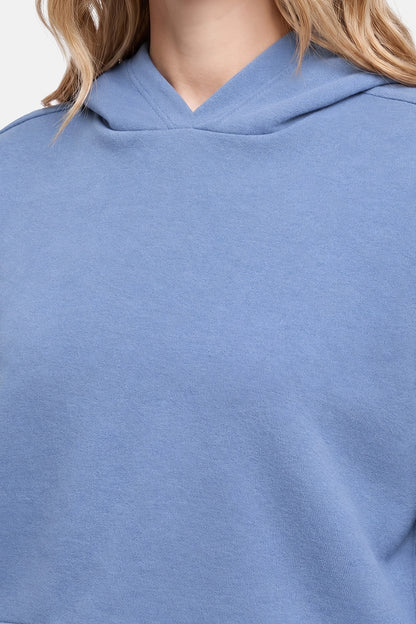 Close-up of a person wearing a light blue hooded sweatshirt, showing the hood and upper chest area.