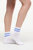 White socks with blue stripes worn by a woman on a white background. 