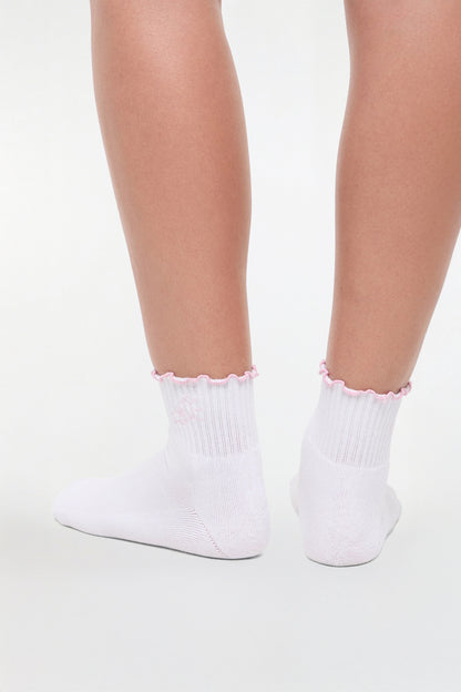 Back view of white socks with lilac ruffled trim and cheer megaphone graphic worn by a woman on a light background. 