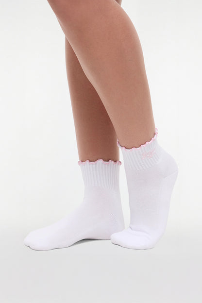 Side view of white socks with lilac ruffled trim and &