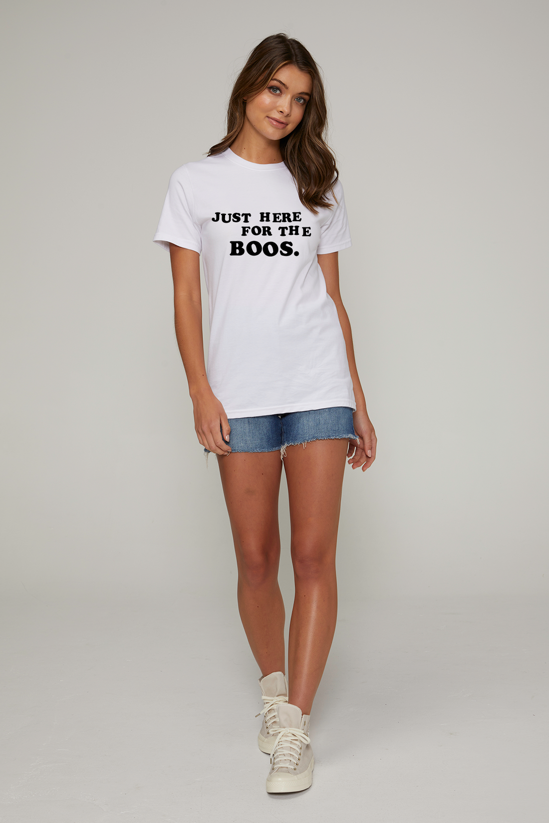 A woman wearing a white crew neck t-shirt with the text &