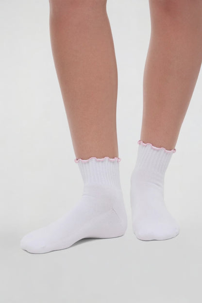 Video view of white socks with lilac ruffled trim and cheer megaphone graphic worn by a woman on a light background. 