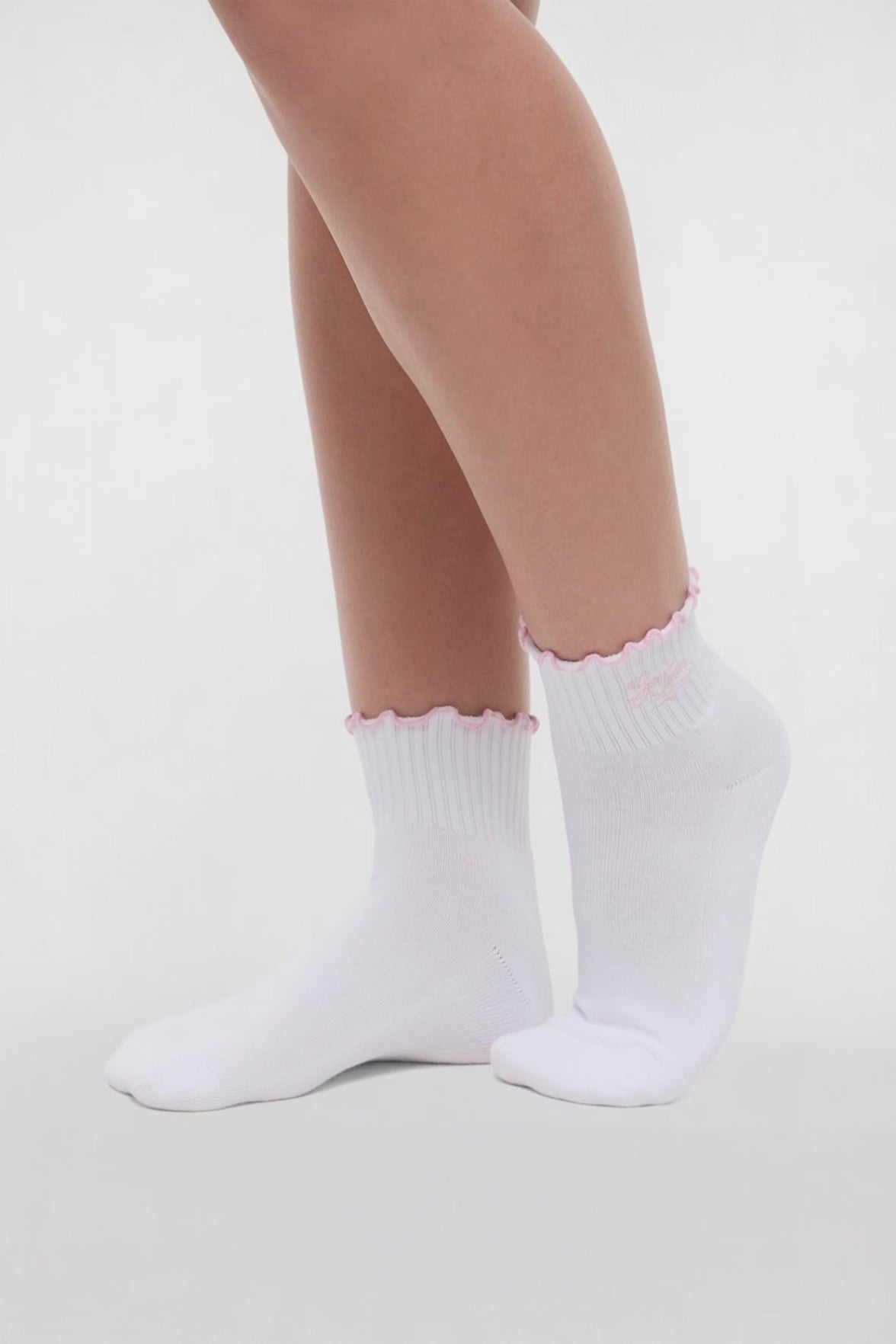 Video view of white socks with lilac ruffled trim and 'GO TEAM!' text worn by a woman on a light background. #color_white-burnished-lilac