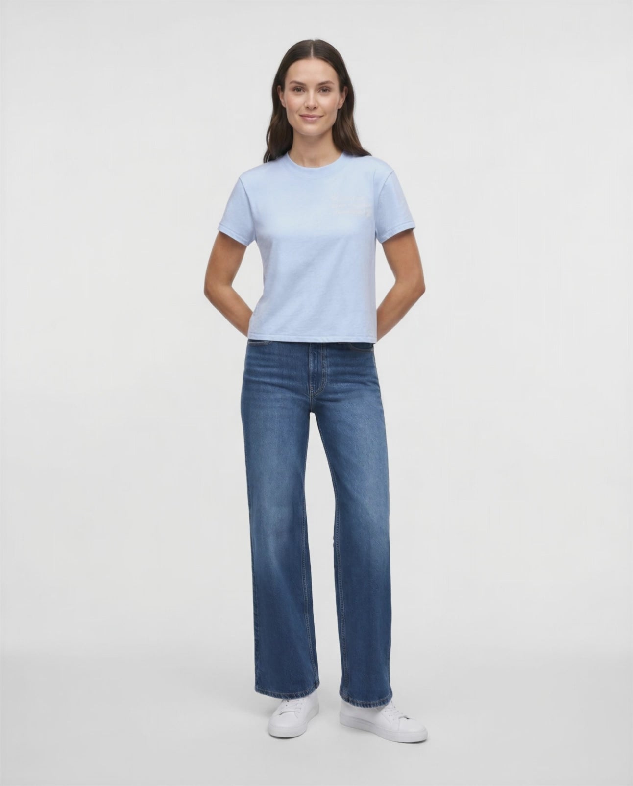 Video view of woman wearing a light blue t-shirt with embroidered &