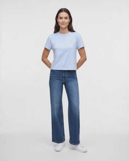 Video view of woman wearing a light blue t-shirt with embroidered &