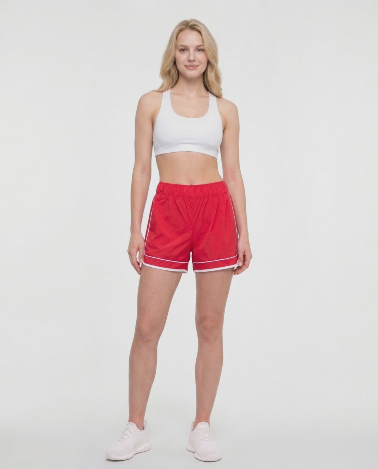 Video view of red athletic shorts with white trim worn by a woman on a white background. #color_salsa