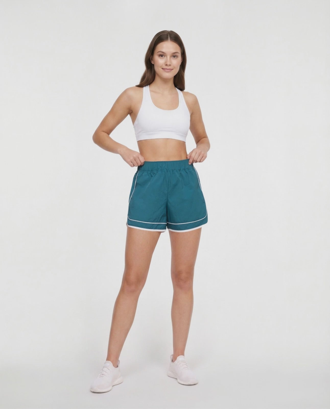 Video view of teal green athletic shorts with white trim worn by a woman on a white background. 