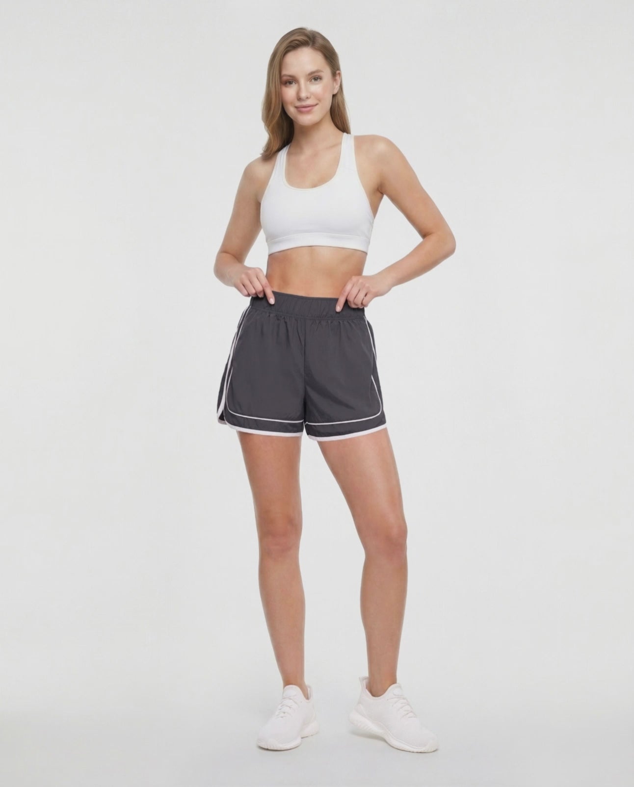 Video view of dark gray athletic shorts with white trim worn by a woman on a white background. #color_pirate-black